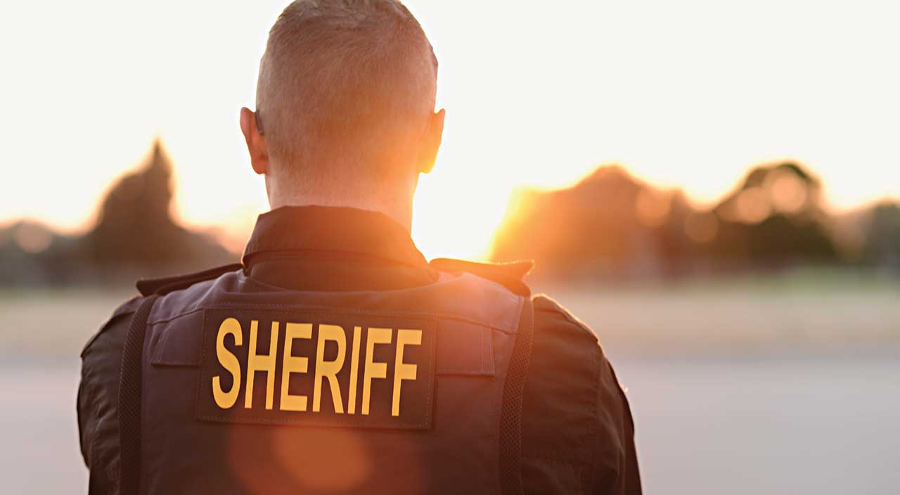 Photo of an officer's back, showing the words "Sheriff"