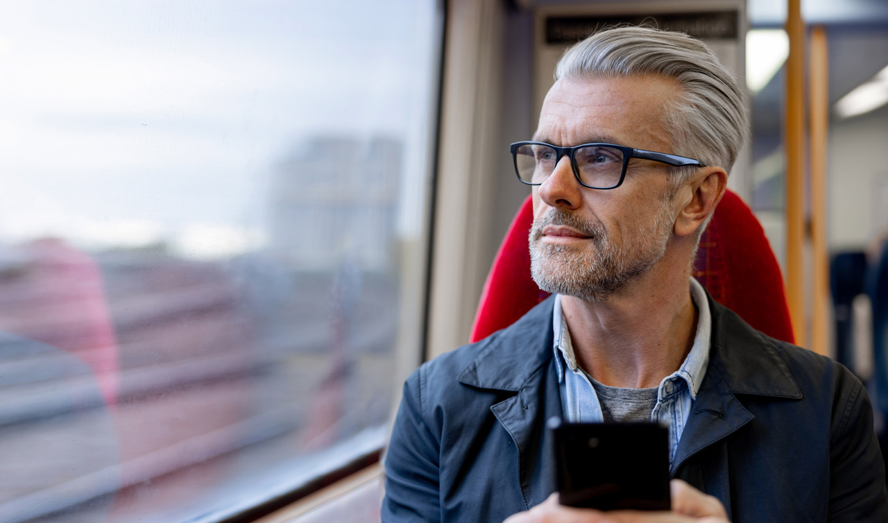 Photo of man looking out the window of a high speed train