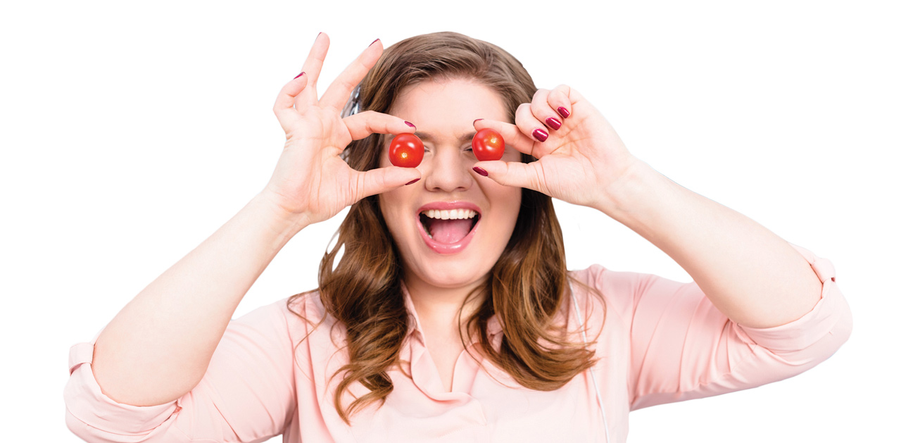 Photo of woman playing with small tomatoes