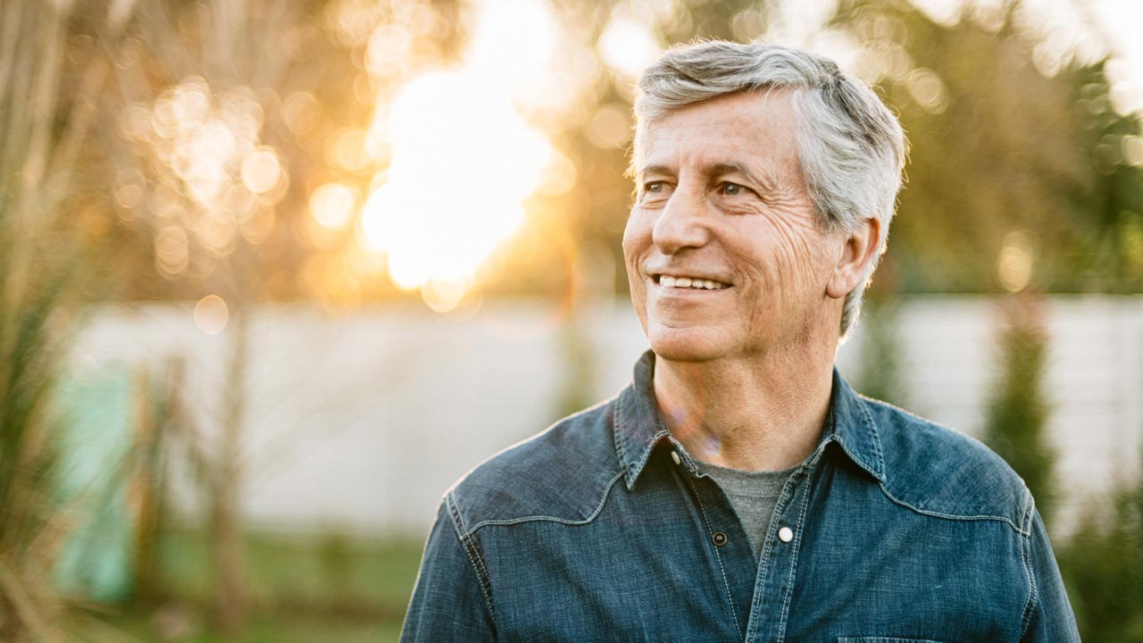 Photo of mature man smiling and looking at the distance