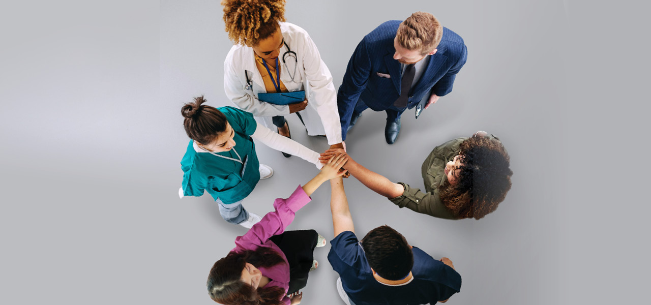 photo of diverse group of healthcare providers and administrative professionals in a team huddle