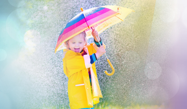 photo of girl playing with umbrella in the rain on a sunny day