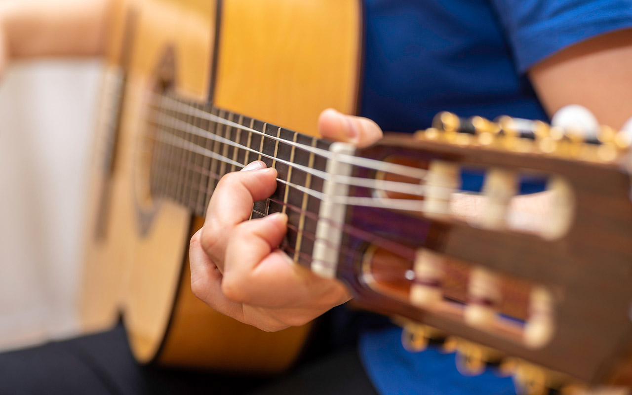 Closeup image of hand playing a classic guitar