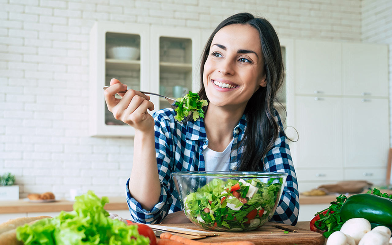 Image of happy woman eating a salad