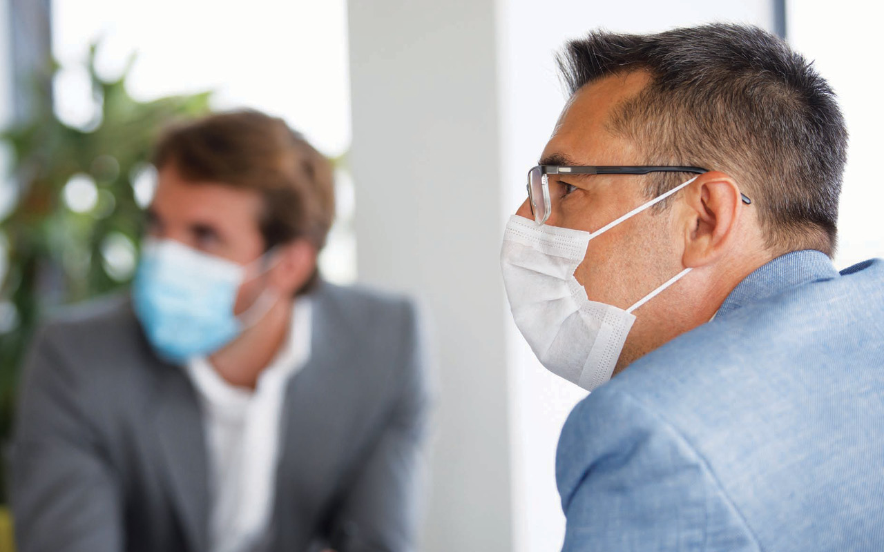 Photo of men at work wearing face masks