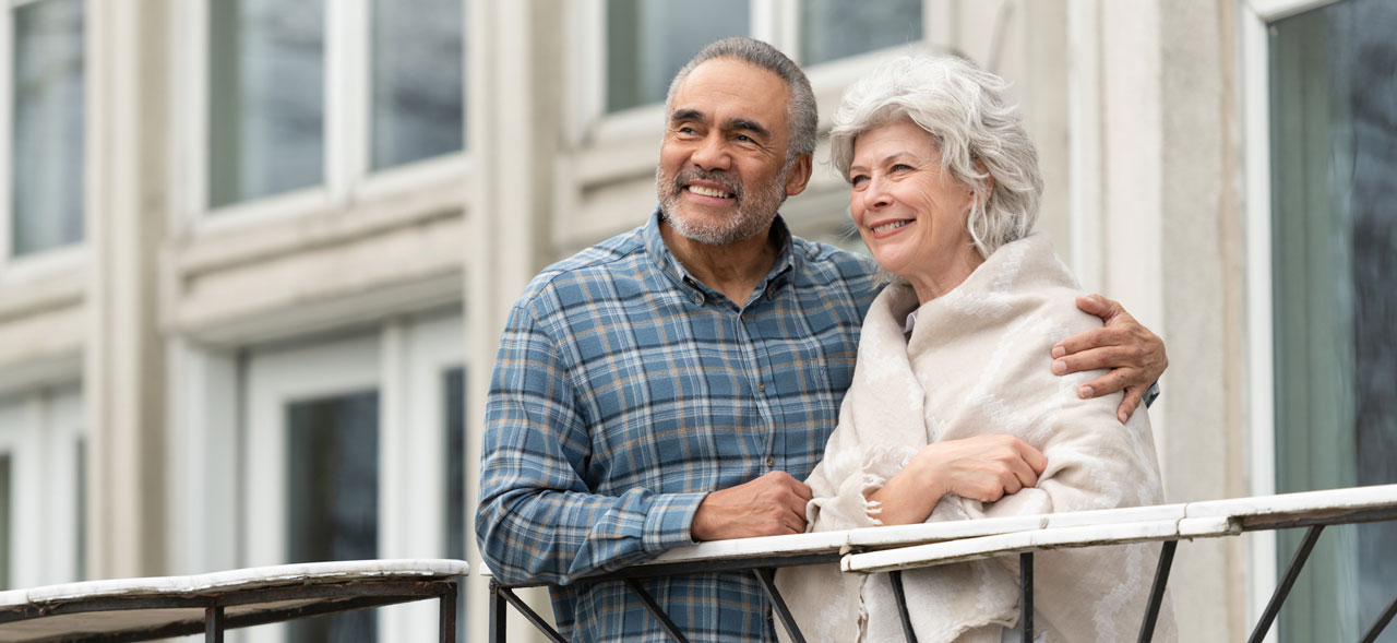 Photo of senior couple looking over balcony